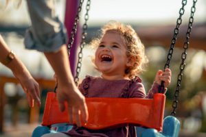 Adorable little girl having fun on a swing. Correct Dose.