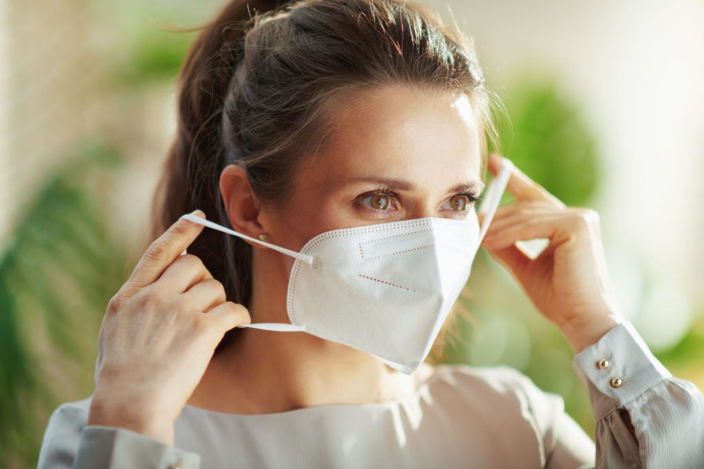 woman in grey blouse wearing kn95 face mask