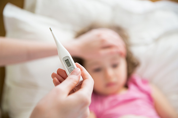 Mother taking child's temperature with a digital thermometer